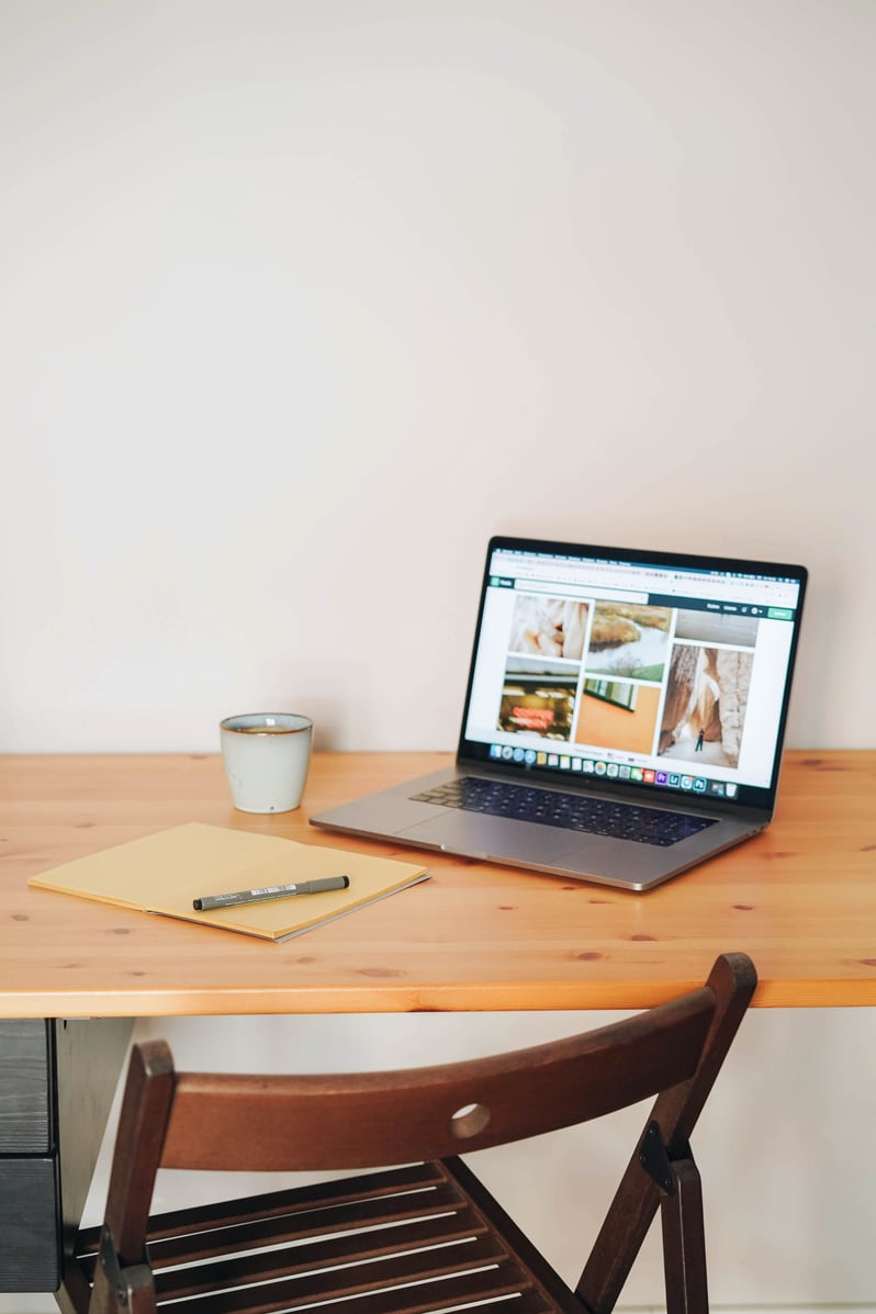 Laptop and Notebook on Wooden Desk